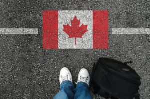 Image of Canadian flag, feet and backpack