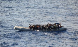 Image of small boat filled with immigrants
