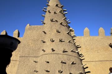 Residents of Timbuktu pass by Djingareyber Mosque. The Mosque is one of the historical architectural structures which together earned Timbuktu the designation of World Heritage Site by UNESCO.