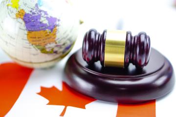 Flag of Canada with Judge hammer and globe world map on top.